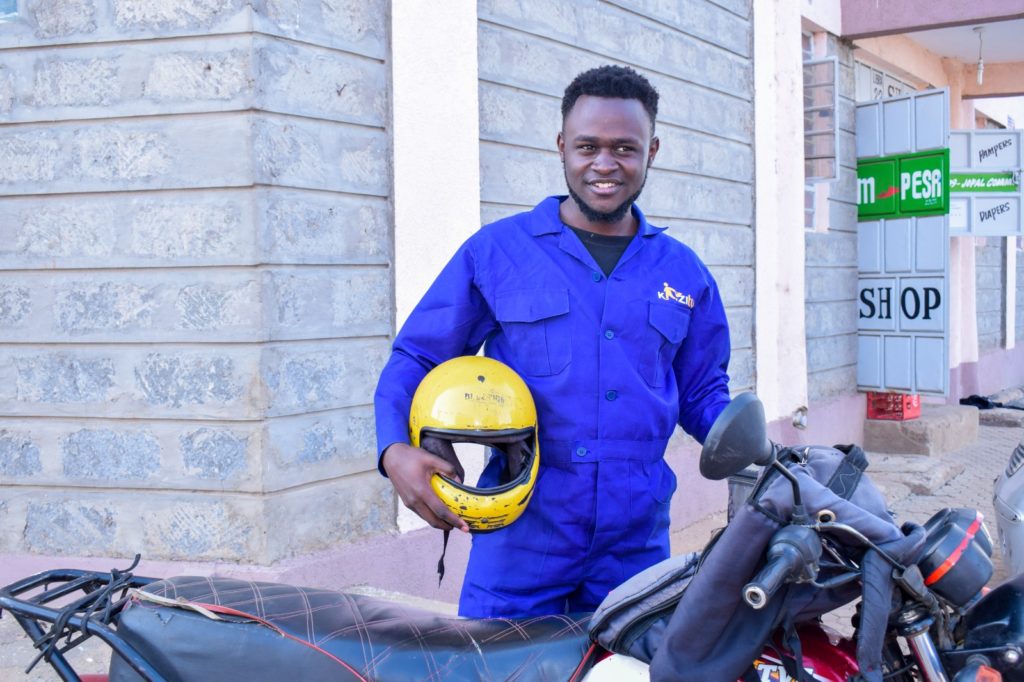 Moses Ayiga, poses after completing a delivery of hygiene and care packages to residents of Kangemi, Nairobi.