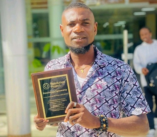 Lincoln Olatunji proudly grasping an award as a Catalyst for Change