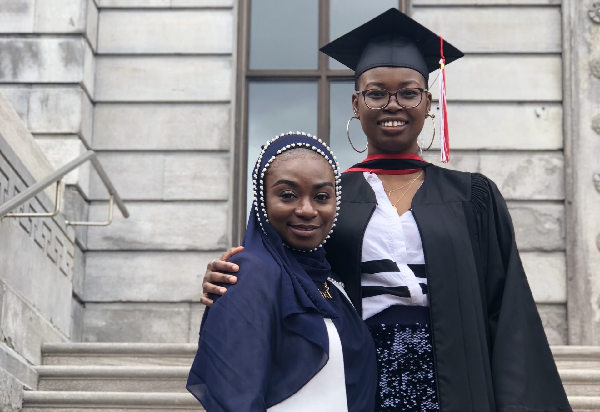 The image of Ipti, a Mastercard foundation scholar wearing a graduation gown with a friend