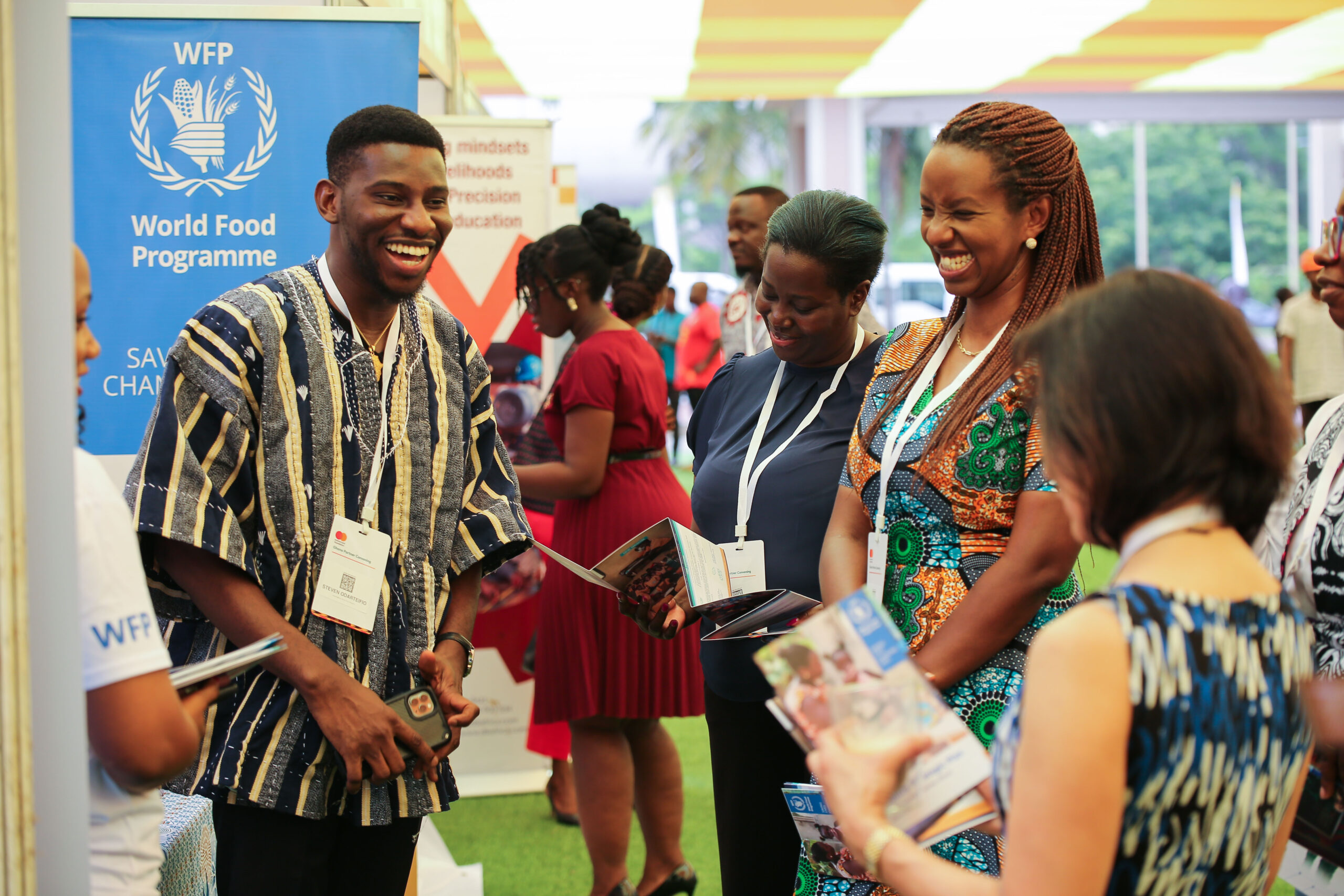 Reeta Roy, President and CEO of the Foundation, Rosemary Nduhui, Executive Director of Country Programs, and Rica Rwigamaba interacting with a representative of the World Food Program (Ghana) at their exhibition booth.